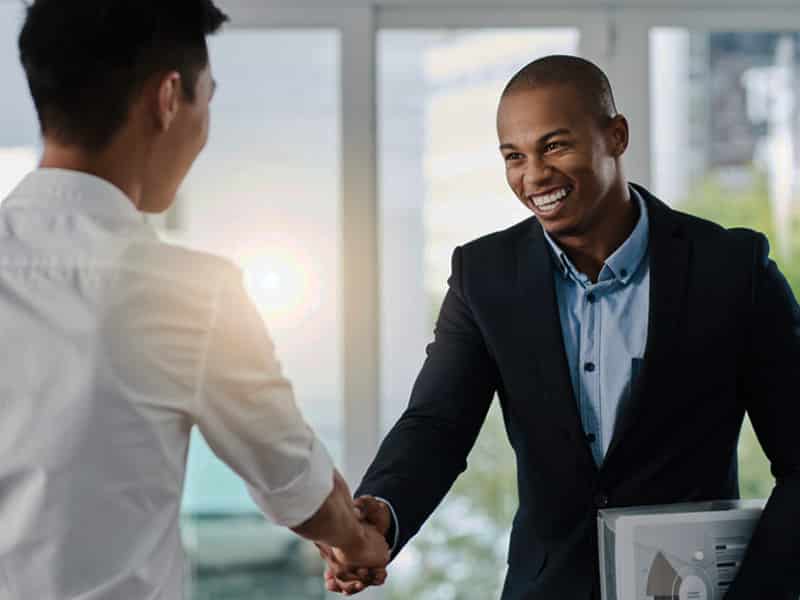 Shot of two young businessmen shaking hands in a modern office